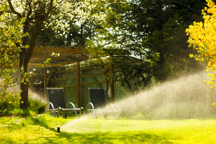 Lawn sprinkler Gardening. Lawn sprinkler spraying water over grass.